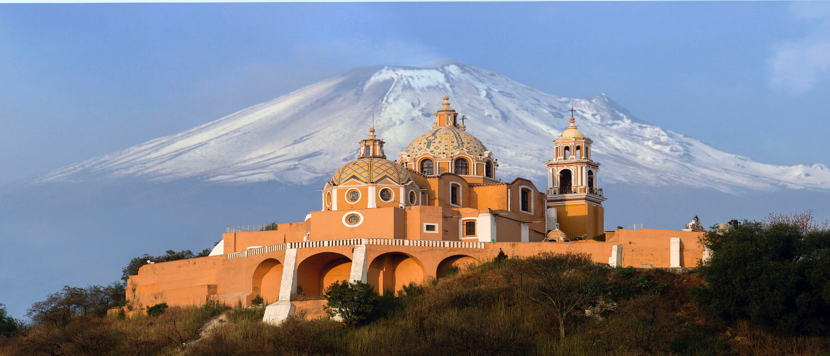Église de Cholula dans l'état du Puebla sur fond de montagne enneigée au cours d'un voyage au Mexique sur mesure avec une agence locale Nirvatravel