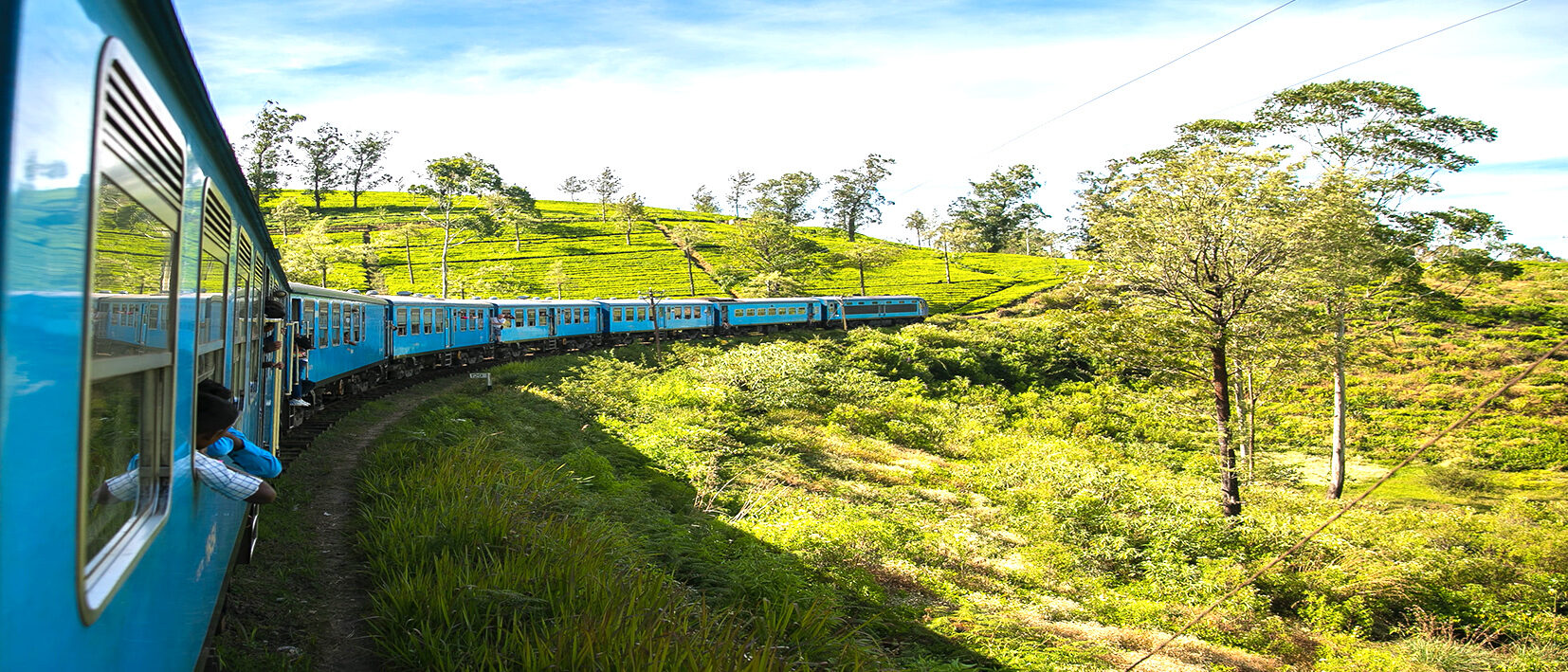 Train bleu de Ella traversant les collines et plantations de thé au cours d'un voyage sur mesure au Sri Lanka avec une agence locale Nirvatravel